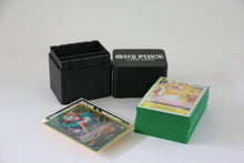 standard_one_piece|One Piece Standard deck box open beside the logo lid, with a full sleeved deck and leader cards laid out