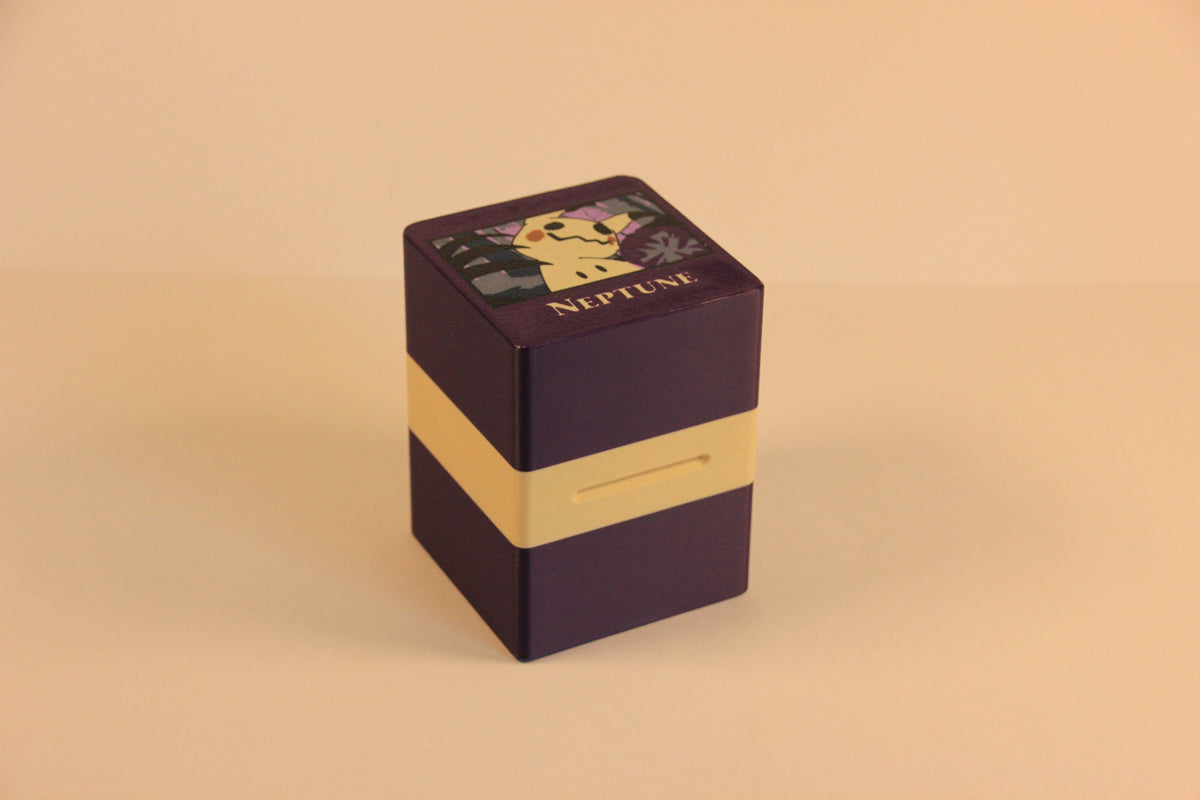 standard_pokemon|Purple and cream Pokémon Standard deck box closed, showing the Mimikyu lid graphic and Neptune nameplate