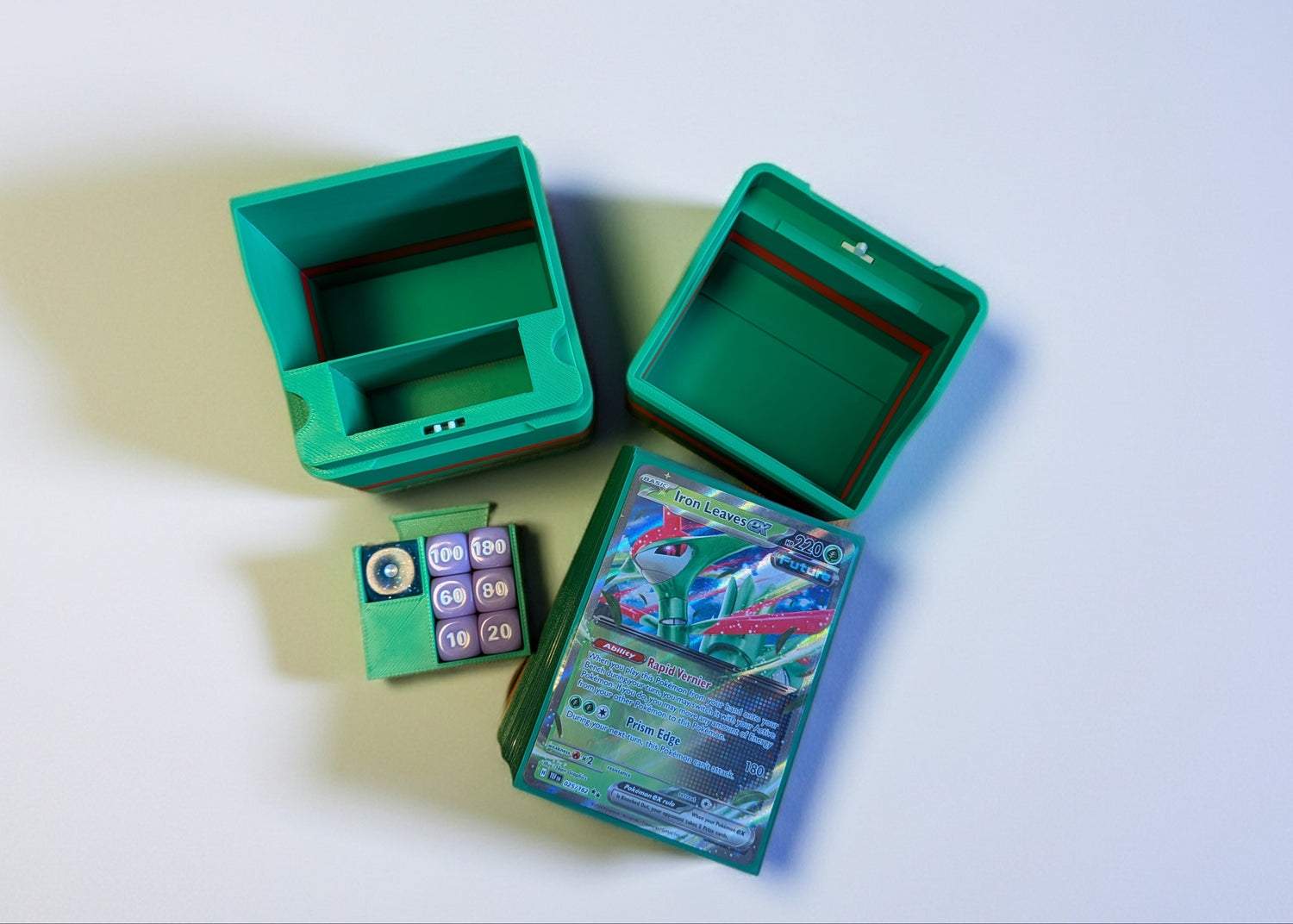 standard_pokemon|Green and red Pokémon Standard deck box opened into its compartments with a dice tray and Iron Leaves ex card