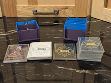 standard_riftbound|Both halves of the Riftbound Standard deck box empty, with battlefield, rune and unit card stacks laid out in front