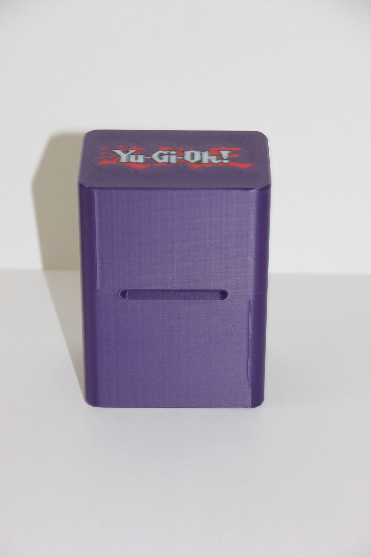 standard_yugioh|Purple Yu-Gi-Oh deck box on its side showing the front card slot