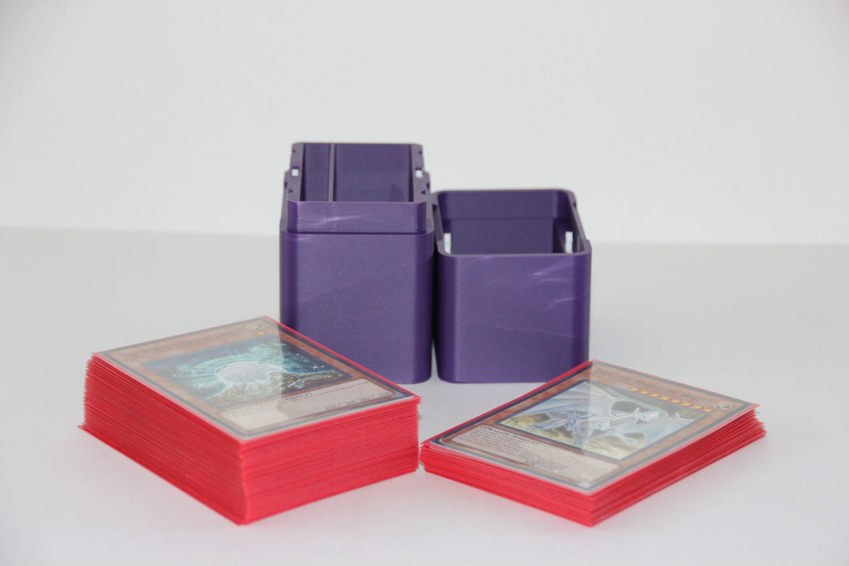 standard_yugioh|Purple Yu-Gi-Oh deck box standing open beside two sleeved deck stacks